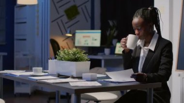 Afrikalı Amerikalı siyahi kadın gece geç saatlere kadar ofis toplantı odasında çalışıyor.
