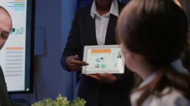 İdari yönetici, toplantı odasında çalışan siyahi kadın şirket yönetimi istatistiklerini açıklıyor.