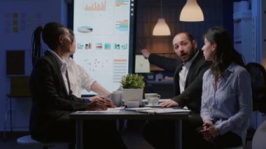 Çeşitli iş adamlarının şirket stratejisini analiz edip kurumsal istatistikleri tartışması.
