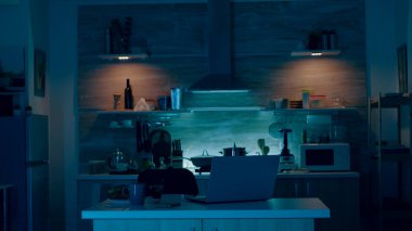 Mutfağa elinde cep telefonuyla gelip sesli komut veren genç.