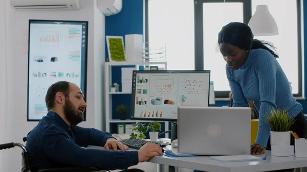 African entrepreneur making project presentation for invalid colleague — Stock Photo, Image