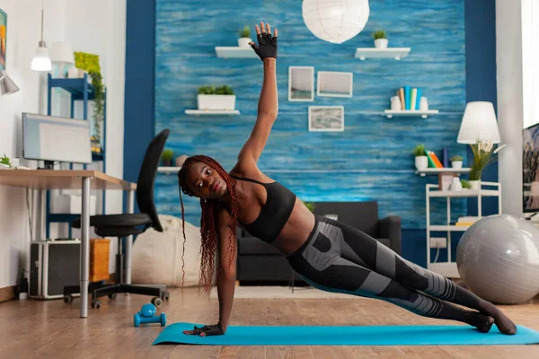 In forma atletica donna nera in piedi in tavola laterale su tappetino yoga — Foto Stock