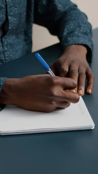 Afro-Amerikaanse zwarte persoon het schrijven van notities op notitieblok met behulp van een pen — Stockfoto