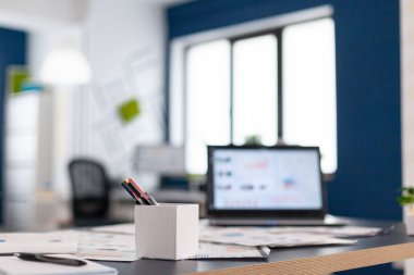 Masasında dizüstü bilgisayarı olan ılımlı bir şirket ofisi.