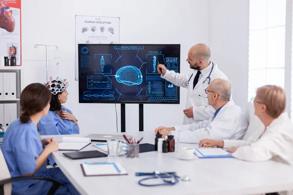 의사가 병원 동료들에게 의료 방사선 검사를 가리키면서 뇌 질환을 분석 한다 — 스톡 사진
