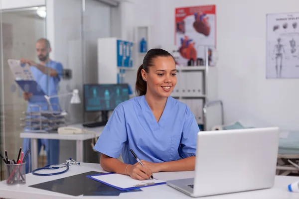 Usmívající se zdravotní sestra pomocí notebooku — Stock fotografie