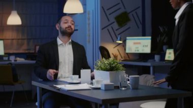 Ofis toplantı odasında çalışan çok ırklı takım çalışması finansal grafikleri tartışıyor