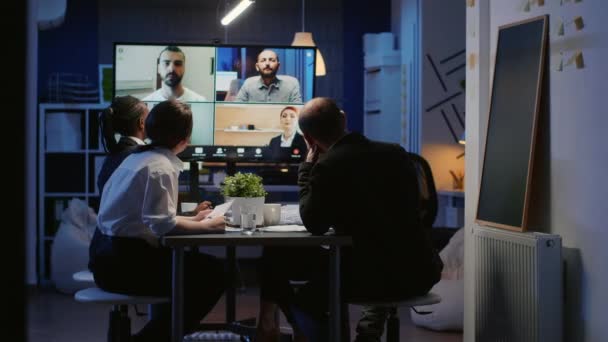Разнообразная группа бизнес-команд обсуждает с удаленными коллегами во время онлайн-видеоопроса — стоковое видео