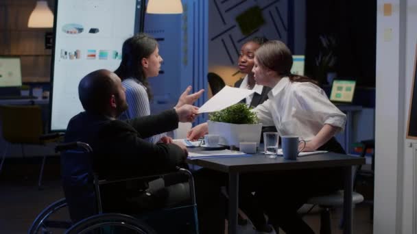 Handicapped paralyzed manager man in wheelchair sitting at conference table — Stock Video