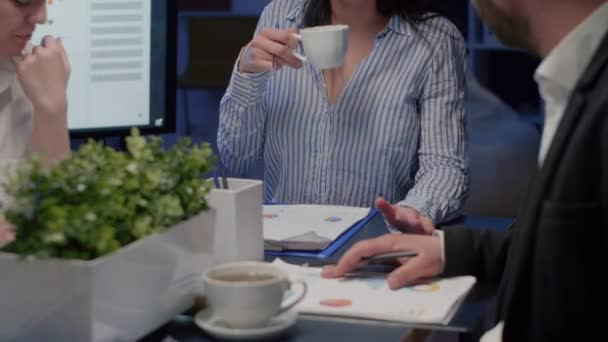 Leder de negocios sosteniendo la taza de café mientras discute con el trabajo en equipo multiétnico — Vídeo de stock