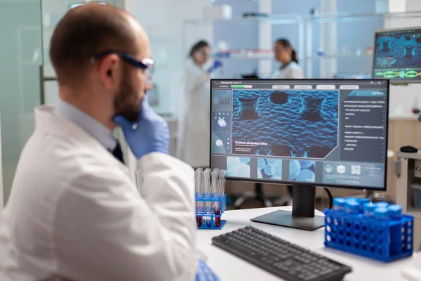 Bilgisayar ekranında virüs evrimini analiz eden düşünceli doktor.