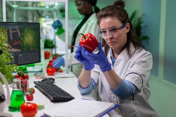 Bióloga mujer examinando pimienta escritura microbiología experiencia médica — Foto de Stock