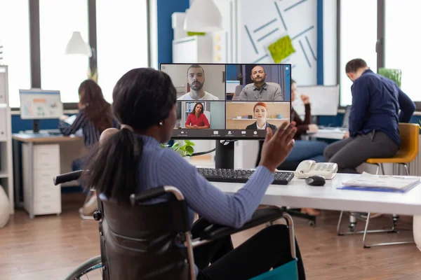 Paralizzato lavoratore nero seduto immobilizzato in sedia a rotelle avendo videomeeting — Foto Stock