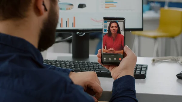 Achteraanzicht van projectmanager met smartphone luisterend remote leader — Stockfoto