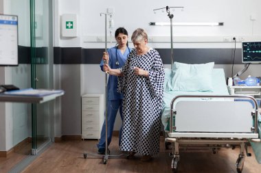 Yaşlı hasta kadın damardan ilaç alıyor.