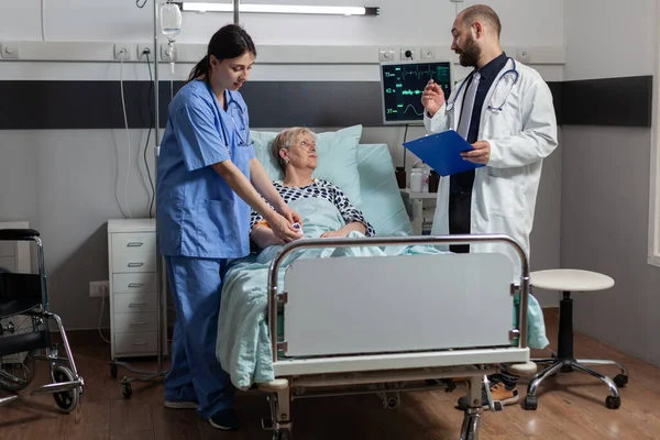 Ιατρική νοσοκόμα που προσκολλάται οξύμετρο σε ηλικιωμένη γυναίκα ασθενή — Φωτογραφία Αρχείου
