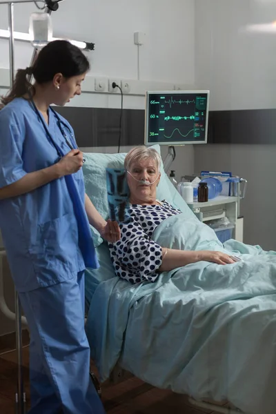 Infermiere medico che spiega radiografia toracica a pazienti anziani — Foto Stock