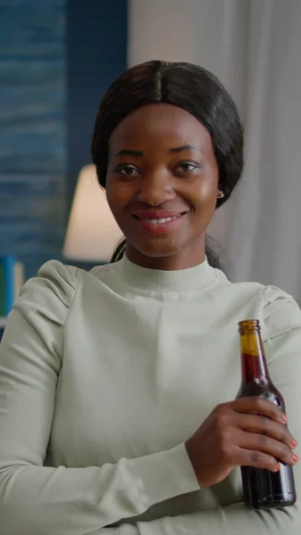 Fröhliche Frau mit dunkler Haut trinkt Bier und amüsiert sich auf Ferienparty — Stockfoto