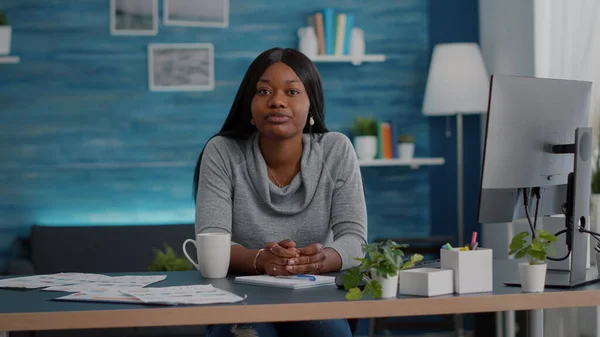 Pov of african american woman sitting at desk in living room looking into camera having online videocall — Stock Photo, Image