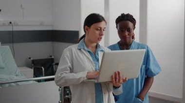 Çocuk hastalıklarının iyileşmesini tartışan çocuk doktoru laptopta tıbbi uzmanlık gösteriyor.