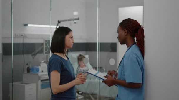 Africký americký lékař zdravotní sestra sledování nemoci symptom vysvětlující lékařské ošetření — Stock video