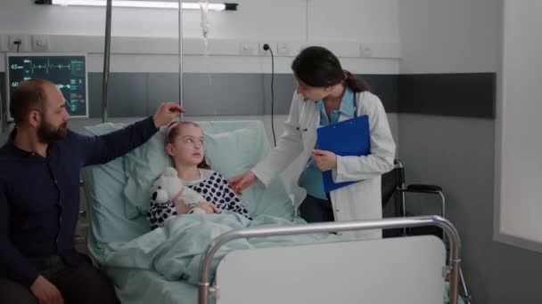 Paciente enfermo descansando en la cama usando tubo nasal de oxígeno discutiendo con pediatra médico — Vídeos de Stock