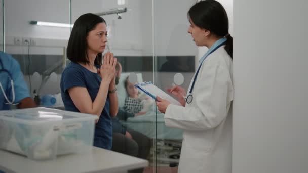Lékař lékař vysvětlující nemocenskou diagnózu panikařené ustaraná matka diskutující o léčbě onemocnění — Stock video