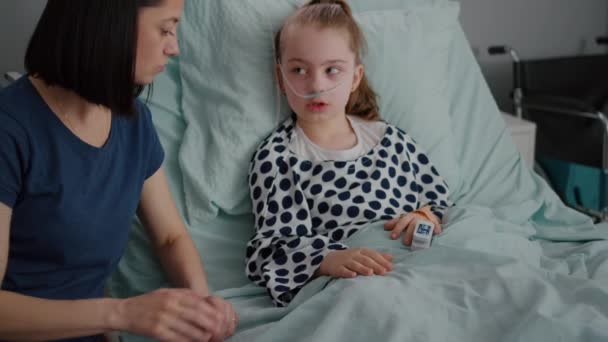 Nemocniční dítě s kyslíkovou nosní trubicí spočívající v posteli s lékařským oximetrem na prstu — Stock video