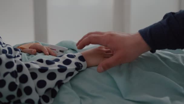 Closeup του άρρωστου παιδιού που αναπαύεται στο κρεβάτι με οξύμετρο για την παρακολούθηση δακτυλικών αποτυπωμάτων εμπειρογνωμοσύνη σε ασθένειες — Αρχείο Βίντεο
