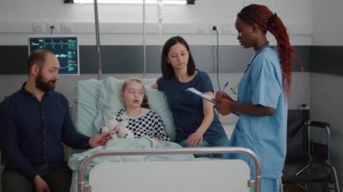 Afrikalı Amerikalı çocuk hemşiresi endişeli ebeveynlere tedaviyi açıklıyor