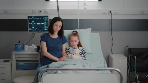 Portret van bezorgde moeder en meisje kind op zoek naar camera durinh ziekte therapie onderzoek — Stockvideo