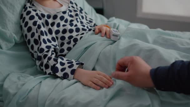 Close-up van vader zitten met zieke dochter in ziekenhuis afdeling hand in hand — Stockvideo