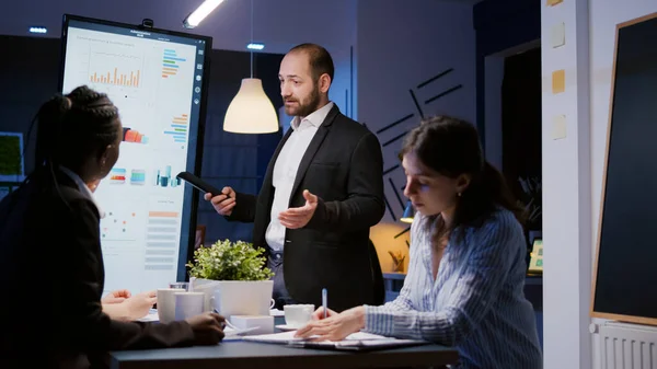 Fokuserad man ledare förklarar ledningsprojekt med hjälp av bildskärm arbetar i företagets möte kontorsrum — Stockfoto