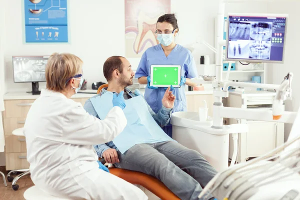Pielęgniarka medyczna gospodarstwa makiety zielony ekran chroma klucz tabletka — Zdjęcie stockowe