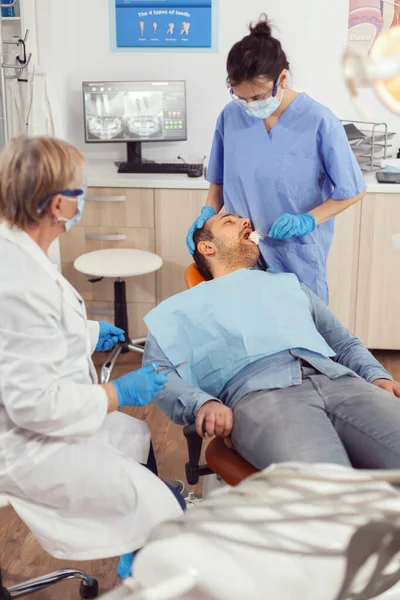 Старший стоматолог женщина готовится к операции поставить имплантат больным — стоковое фото