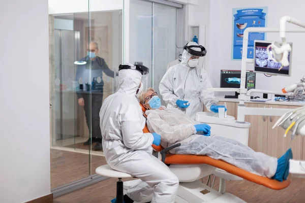 Старший пациент в защитном костюме во время коронавируса — стоковое фото