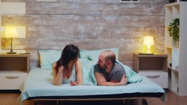 Pijama giyen neşeli çiftin fotoğrafını yakınlaştır.