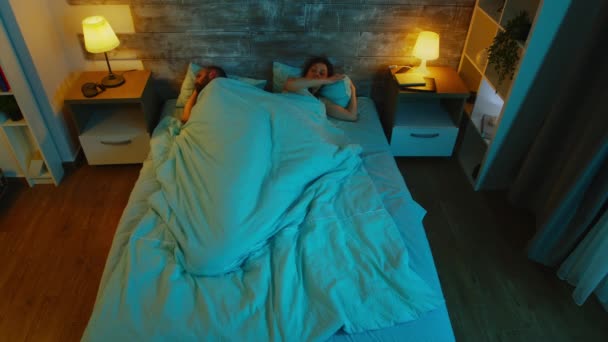 Vue du dessus du jeune couple sous les draps ne peut dormir — Video