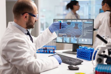 Klinik deneyi yapan bilim adamı kan örneği tutuyor.