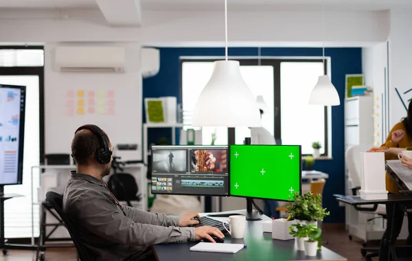 Homme vidéaste avec casque de travail à l'écran vert ordinateur — Photo