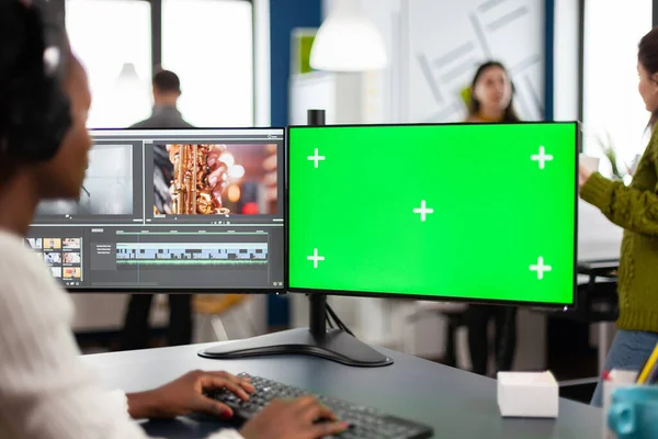 Yeşil ekranlı pc kullanarak kulaklık düzenleme görüntüleriyle Afrikalı video düzenleyici — Stok fotoğraf