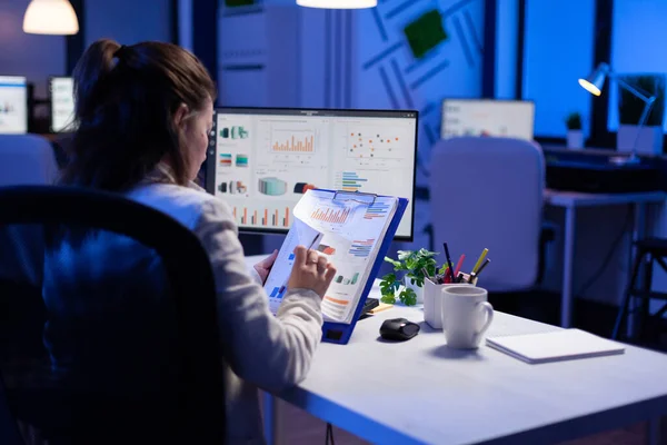 Freelancer mujer comparando gráficos de portapapeles con gráficos de computadora — Foto de Stock