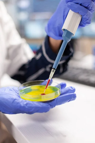 Крупный план врача, сбрасывающего образец крови с помощью микропипетки — стоковое фото