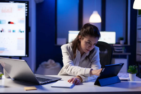 Gestionnaire femme utilisant ordinateur portable et tablette en même temps travailler sur des rapports financiers — Photo