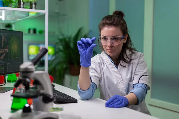 Científico bioquímico analizando muestras líquidas verdes usando microscopio —  Fotos de Stock