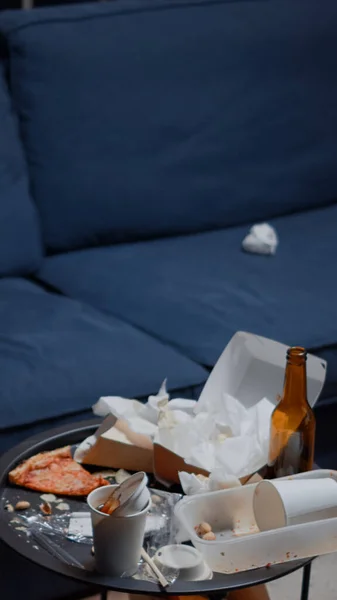 Хаос у порожній вітальні з їжею сміття на столі — стокове фото