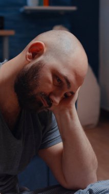 Savunmasız depresif bir adam yalnız başına oturmuş duygusal olarak dengesiz hissediyor.