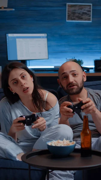 Konzentriertes entschlossenes Paar spielt spätabends Videospiel — Stockfoto