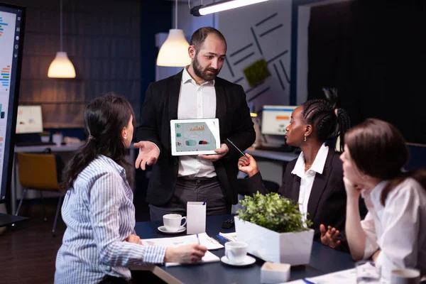 Hombre de negocios sobrecargado mostrando gráficos financieros presentación usando tableta — Foto de Stock