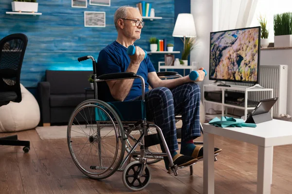 Pensionné invalide en fauteuil roulant entraînement muscles du corps persistance à l'aide d'haltères de gymnase — Photo